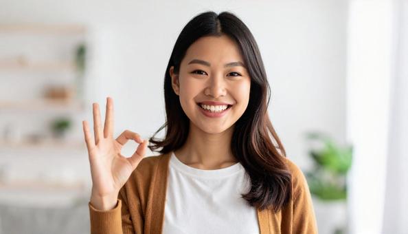 笑顔でOKサインをする女性の写真