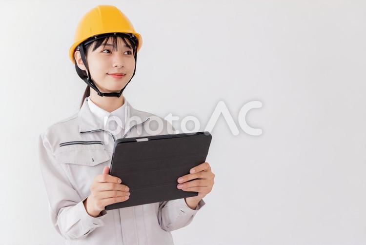 タブレットを使用する作業服の女性 女性,人物,日本人の写真素材