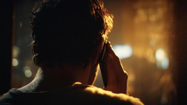 夜の通話：考える男性の後ろ姿の写真