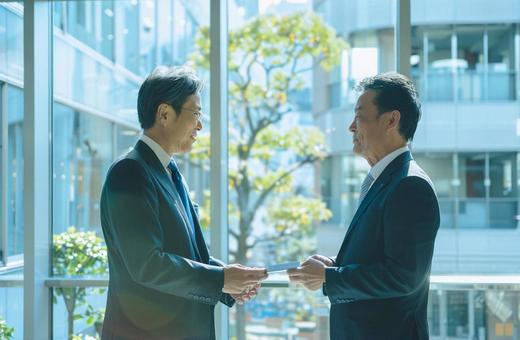 名刺交換するビジネスマンの写真