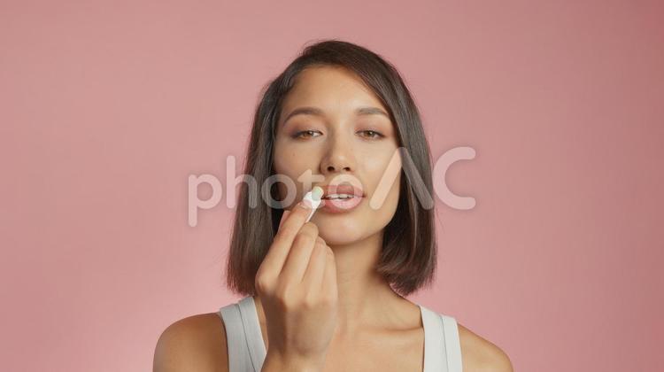 リップクリームを塗るカメラ目線の女性 女性,外国人,アジア人の写真素材