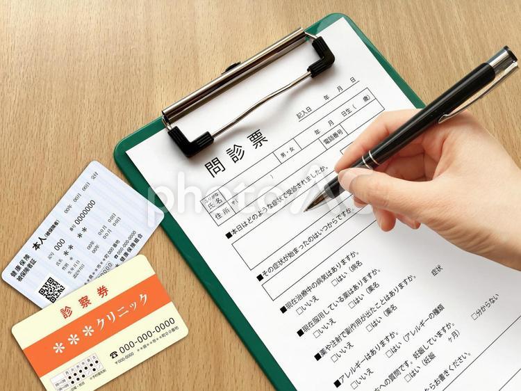 病院の問診票を記入 問診票,保険証,診察券の写真素材