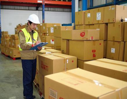 倉庫で在庫をチェックする男性作業員 倉庫で在庫をチェックする男性作業員の写真