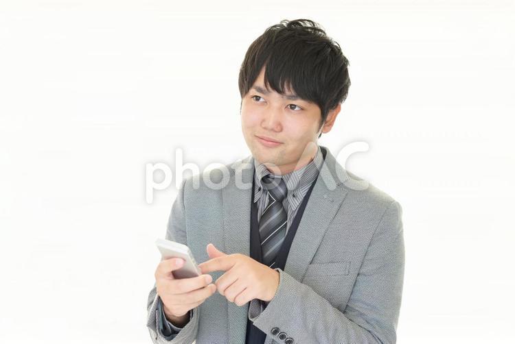 スマートフォンを持つ男性 ビジネス,ビジネスマン,スマホの写真素材