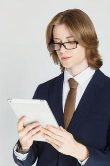 タブレットを使うスーツにメガネをかけた男性 男性,外国人,欧米人の写真素材