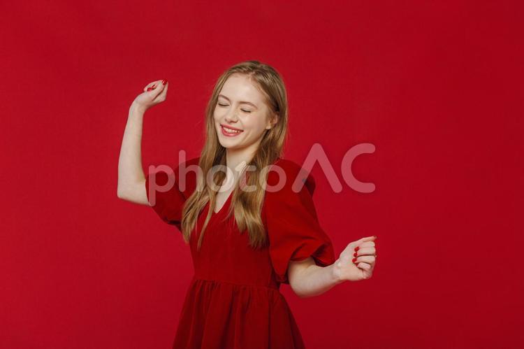 目を瞑って踊る女性（ドレス） 女性,赤,金髪の写真素材