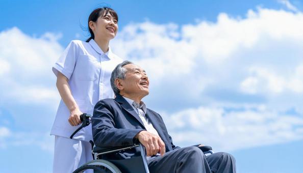 青空を見つめる車いすシニアと介護の女性 青空を見つめる車いすシニアと介護の女性の写真
