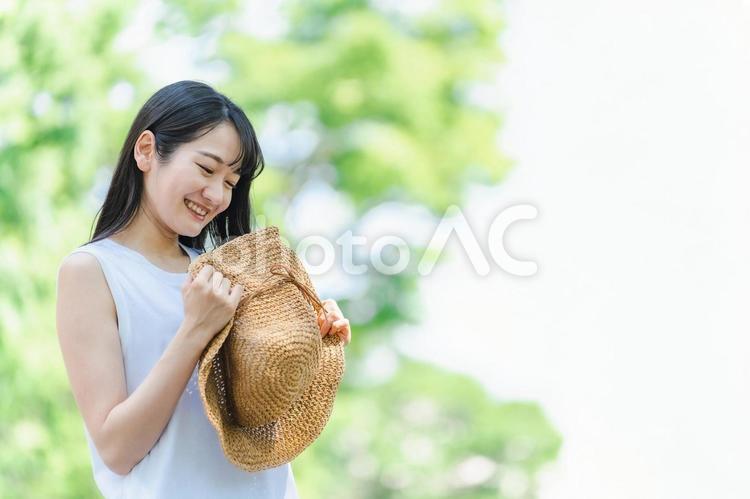 麦わら帽子を持つ女性（夏・笑顔） 夏,女性,旅行の写真素材
