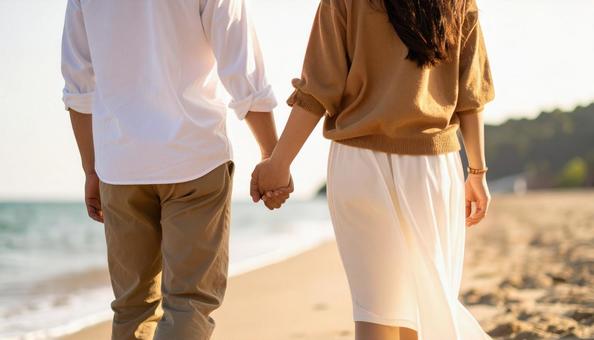 手を繋いで海辺を歩くカップル 手を繋いで海辺を歩くカップルの写真