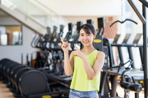 ジムでおすすめする若い女性 ジム,指差し,フィットネスの写真素材