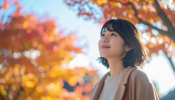 紅葉の鑑賞を楽しむ若い女性 紅葉の鑑賞を楽しむ若い女性の写真