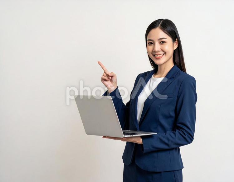 ノートパソコンを持ち案内する会社員女性 ビジネス,窓口,案内の写真素材