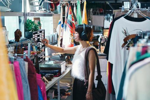 店頭でカセットテープを手に取る若い女性 店頭でカセットテープを手に取る若い女性 カセット,サブカル,カセットテープの写真素材