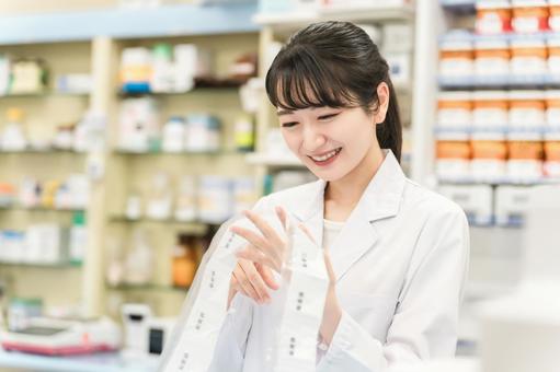 薬局で自動分包機を使って調剤する薬剤師 薬局で自動分包機を使って調剤する薬剤師 くすり,薬局,調剤の写真素材