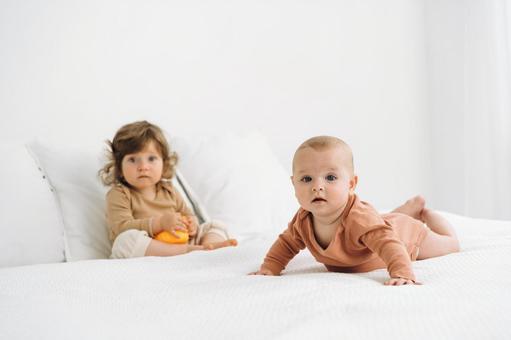 驚いた顔のベッドの上の子供たち 驚いた顔のベッドの上の子供たち 赤ちゃん,かわいい,ベッドの写真素材