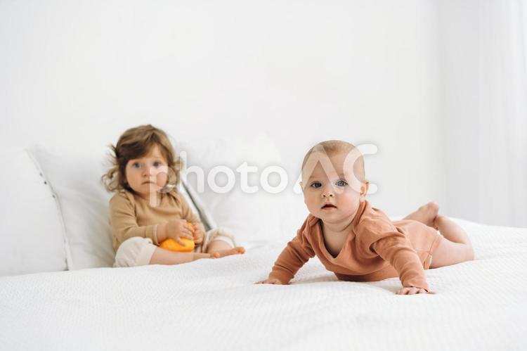 驚いた顔のベッドの上の子供たち 赤ちゃん,かわいい,ベッドの写真素材