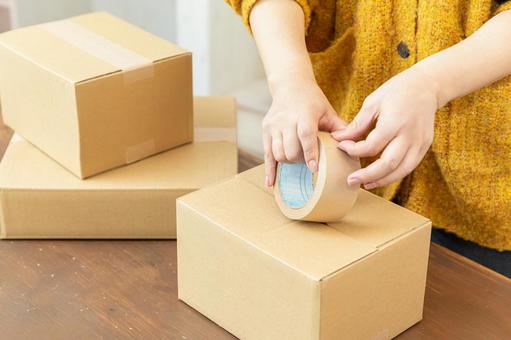 段ボールを梱包する手元 段ボール,ガムテープ,留めるの写真素材