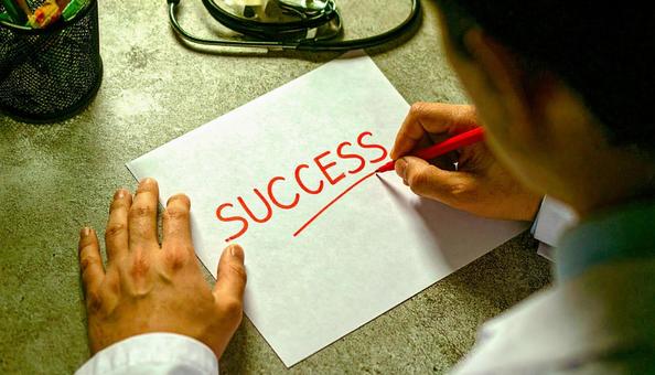 「SUCCESS」を書く男性医師の手もと 「SUCCESS」を書く男性医師の手もとの写真