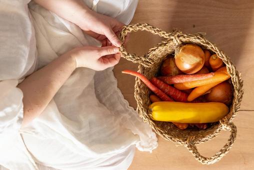 野菜の入ったカゴの持ち手を持つ手 野菜,カゴ,持つの写真素材