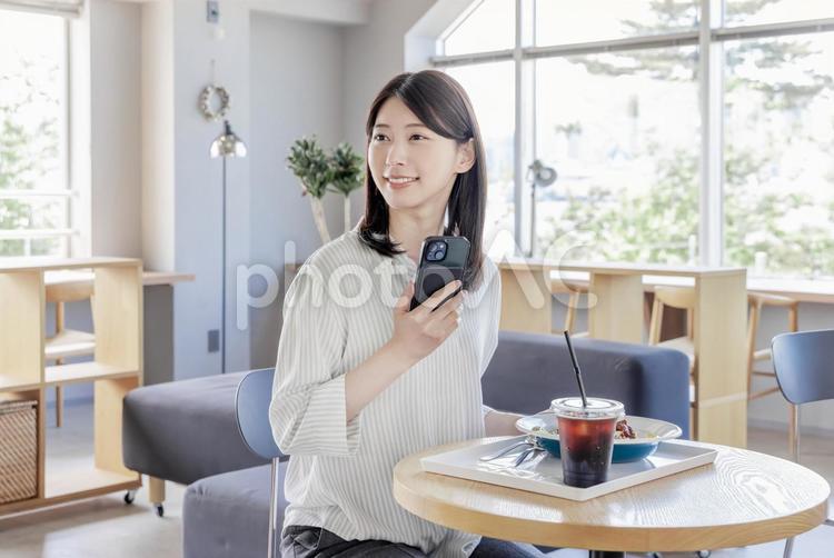 カフェでスマホを使う女性 スマートフォン,携帯電話,携帯の写真素材