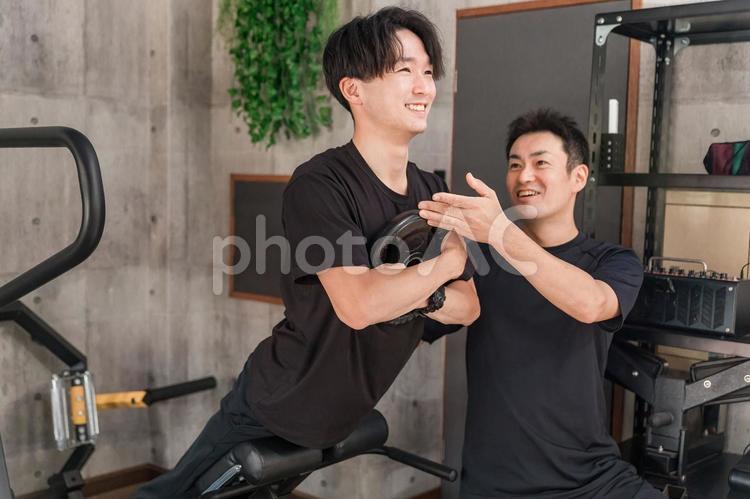 ベンチを使って背筋を鍛える男性 スポーツジム,ジム,背筋の写真素材