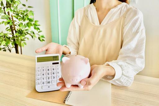 A housewife in an apron managing her household finances, JPG A housewife in an apron managing her household finances, JPG