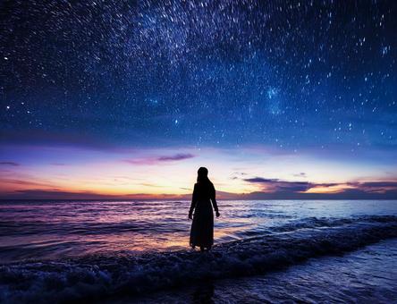 星空と海と女性のシルエット 星空と海と女性のシルエットの写真