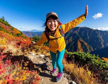 カラフルな登山ウェアで秋の山登る山ガールの写真