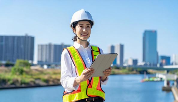 建設現場のヘルメットと作業服の日本人女性 建設現場のヘルメットと作業服の日本人女性の写真