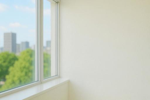 白い壁とビルが見える窓辺の写真