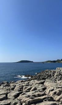 夏の海岸線から見える島 夏の海岸線から見える島の写真
