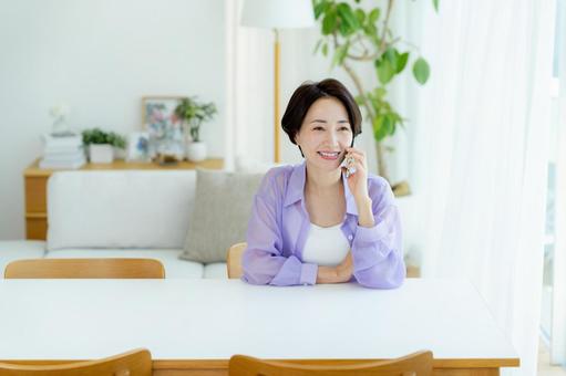 スマホで電話するミドル女性 スマホ,笑顔,女性の写真素材