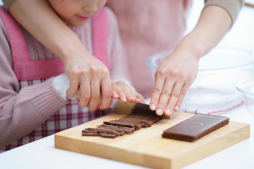 包丁を慎重に扱う親子の手元アップ 女の子,チョコレート,包丁の写真素材