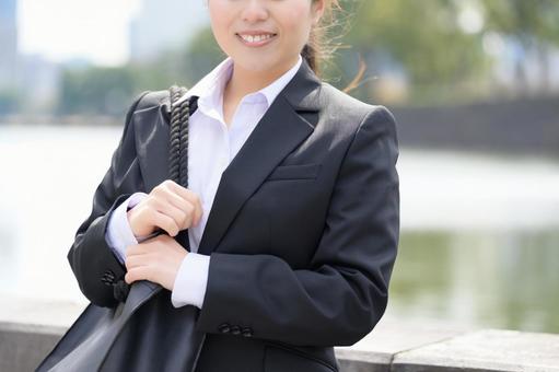 ビル街に立つスーツの女性 ビル街に立つスーツの女性 日本人,女性,20代の写真素材