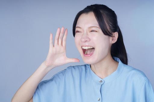 青い服の女性が手を振って笑顔 女性,叫ぶ,呼ぶの写真素材