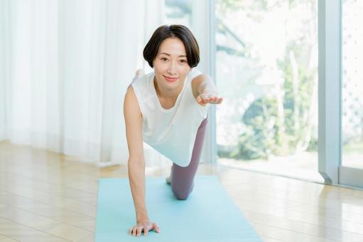 リビングでヨガをする女性 リビングでヨガをする女性 ヨガ,笑顔,女性の写真素材