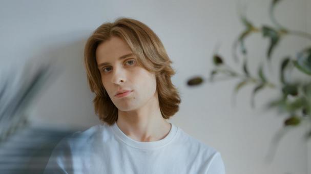 壁にもたれて立つ白いTシャツを着た男性 男性,外国人,欧米人の写真素材