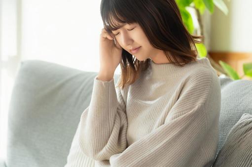 頭を押さえて悩む女性 女性,頭痛,つらいの写真素材