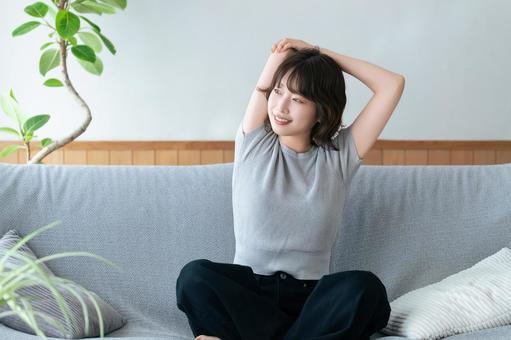 腕を伸ばしてリラックスする女性 腕を伸ばしてリラックスする女性 女性,ソファ,微笑むの写真素材