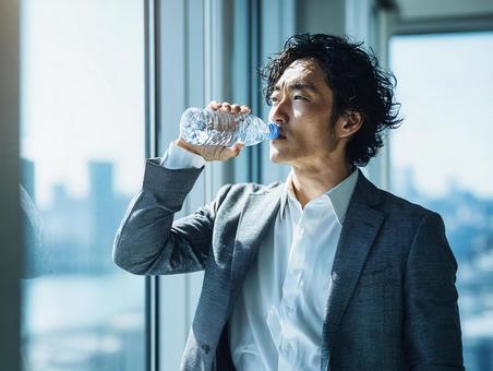 ビジネスシーン：ボトルウォータで喉を潤すの写真