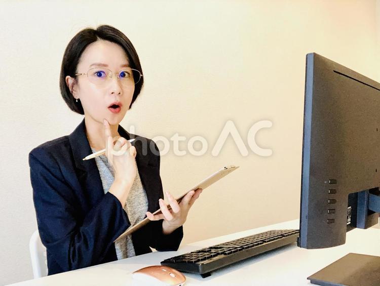 メモをとりながら驚くスーツ姿の女性 女性,在宅ワーク,リモートワークの写真素材