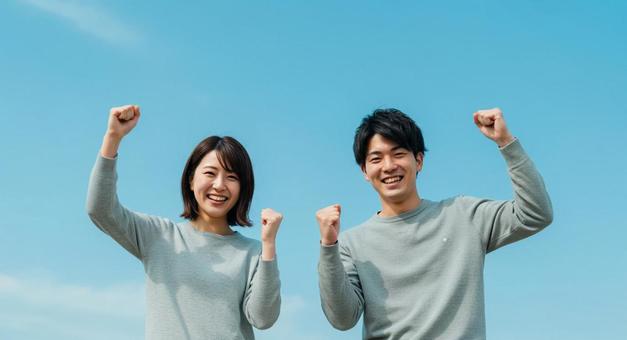 ガッツポーズをとる男女 ガッツポーズをとる男女の写真