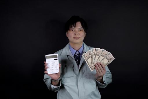 電卓と現金を持つ作業服男性 電卓と現金を持つ作業服男性 作業服,男性,現金の写真素材