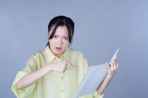 本を指さして怒る黄色い服の女性 女性,バインダー,ファイルの写真素材
