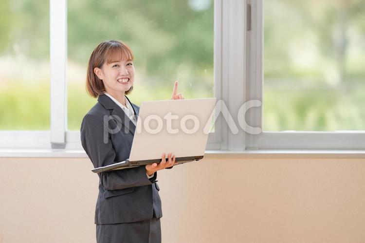 PCと指差す笑顔のビジネスウーマン ビジネスウーマン,スーツ,女性の写真素材