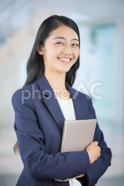ノートを抱えているビジネスウーマン 女性,ビジネスウーマン,会社員の写真素材