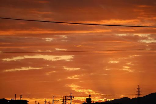 オレンジ色の夕空とシルエットの街並みの写真