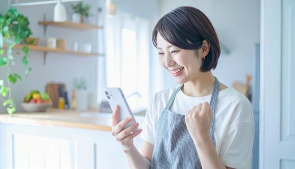 スマホでポイ活する笑顔の女性 スマホでポイ活する笑顔の女性の写真