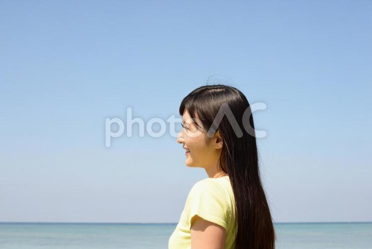 海辺でくつろぐ笑顔の女性 日本,女性,沖縄の写真素材