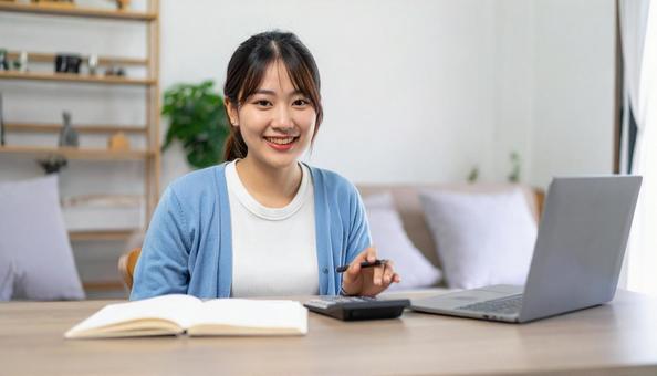 リビングで通帳を笑顔で確認する女性 リビングで通帳を笑顔で確認する女性の写真